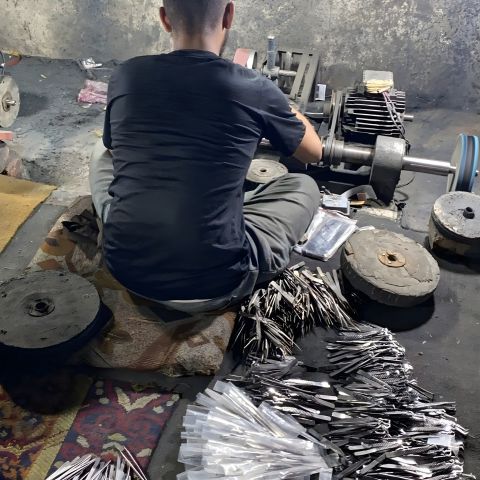 Master craftsman hand finishing salon hair cutting shears at Pure Touch Industry workshop in Sialkot