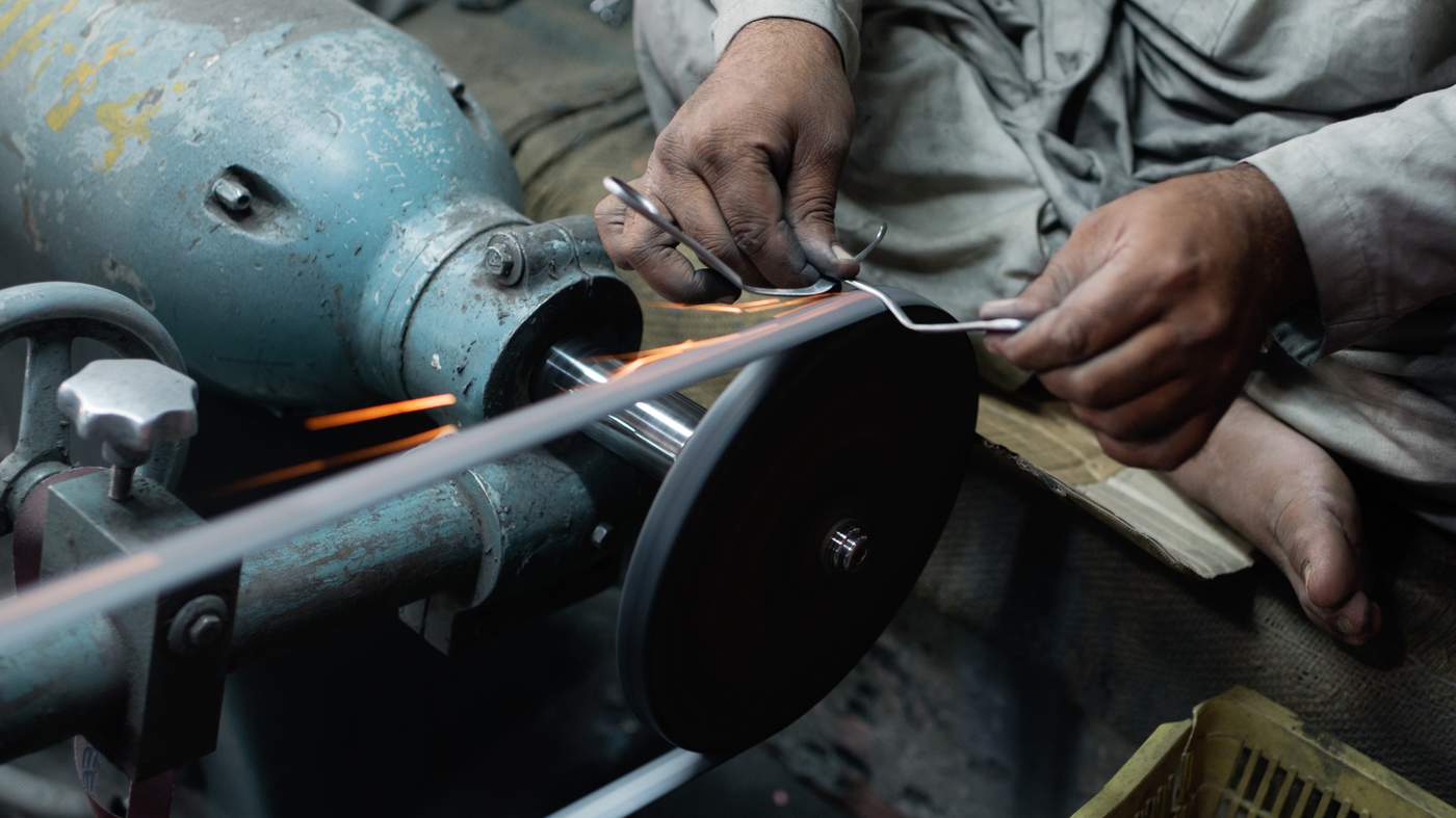 Artisan shaping stainless steel beauty tools at PURE TOUCH INDUSTRY facility